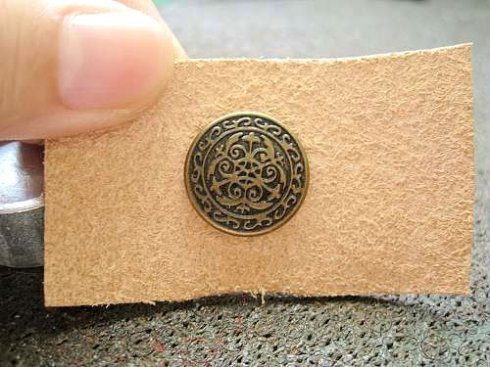 在皮革表面用3.5MM冲子打孔: 将扣面放在底座上: 4.将皮革套在扣面上: 安装上另外一个搭配的零件: 用安装工具组里面有凸出来一点的安装工具进行安装 2022秋冬潮牌新款推荐（羽绒服按扣怎么装 一分钟教你自己动手安装暗扣 ）